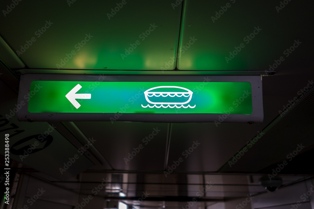 Sign showing the way to lifeboat stations on board a ship Sign showing the way to lifeboat stations on board a ship