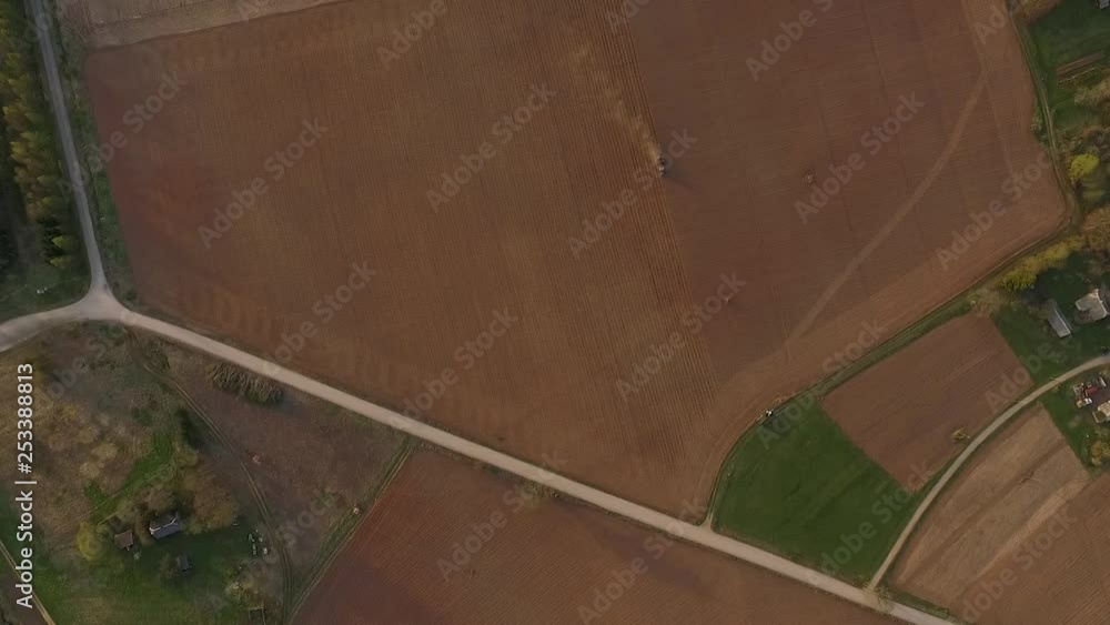 Sowing fields with tractor and seeder in dusty field aerial view Sowing fields with tractor and seeder in dusty field aerial view