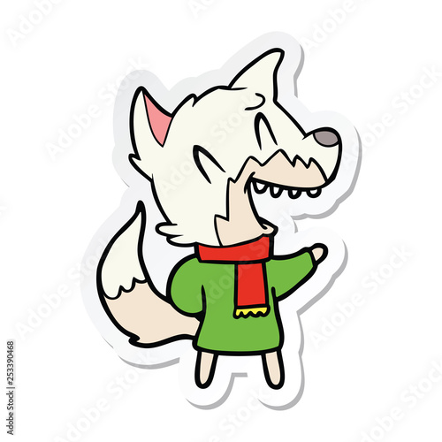 sticker of a laughing fox wearing winter clothes