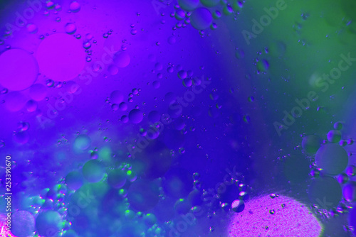 Abstract macro photography. Abstract background. Blue with cyan and purple color. Distortions in water with drops of oil. Bright abstraction  ultraviolet. Circles on the water