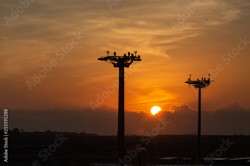 Wallpaper Mural Beautiful sunrise under clouds. Lamp tower of spotlights on the pillars at the airport. Torontodigital.ca