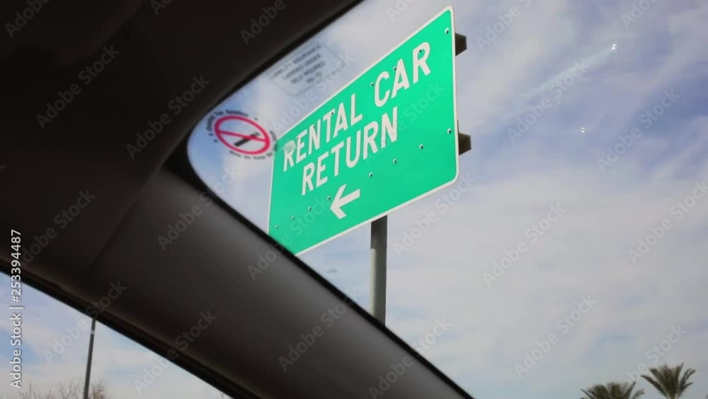Driving by a car rental return sign at the airport in america Stock
