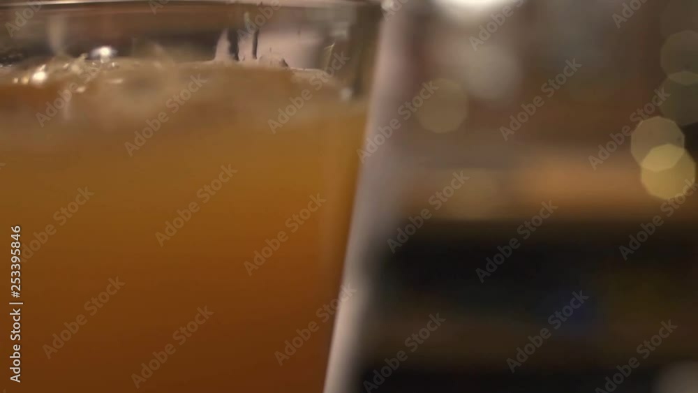 Yellow cocktail being poured into a glass Yellow cocktail being poured into a glass
