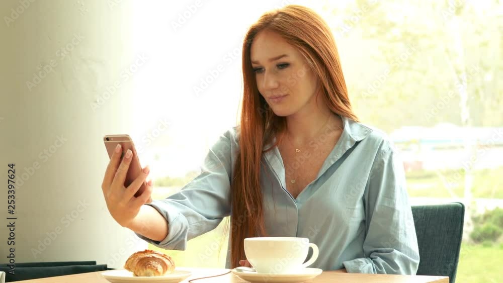 Young, pretty businesswoman taking selfie photo sitting in cafe in the city, 4K