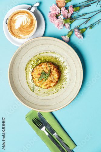 Traditional Italian lasagna. Restaurant table setting on a blue background in a composition with spring cetas and a cup of coffee. Breakfast concept. Top view. photo