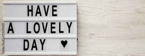 'Have a lovely day' words on lightbox over white wooden background, top view. From above, flat lay, overhead. Copy space.