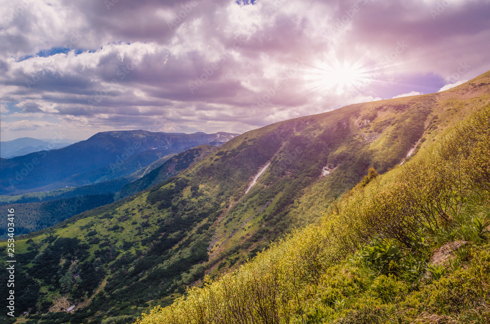 Fototapeta premium dramatic sunset over the mountain top. cloudy pink sky before twilight.