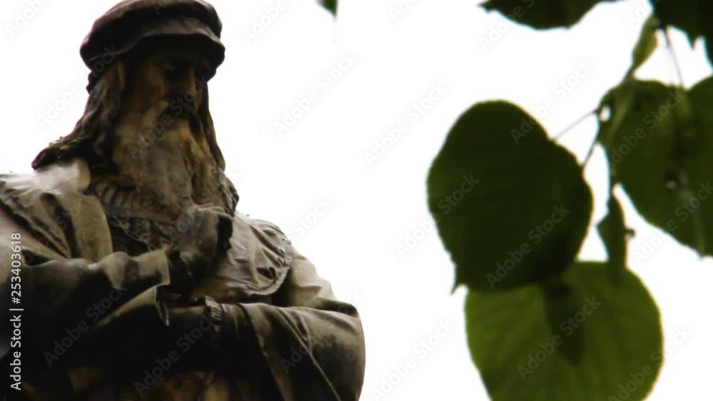 Leonardo Da Vinci Monument in Milan in a rainy day behind the leafs in Milan. Leonardo Da Vinci Monument in Milan in a rainy day behind the leafs in Milan.