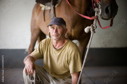 View of a man posing with a horse. photo