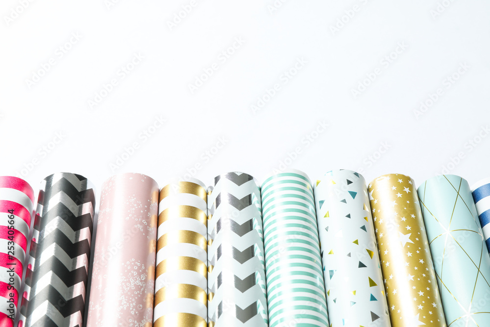 Rolls of festive wrapping paper on white background. Space for text Rolls of festive wrapping paper on white background. Space for text