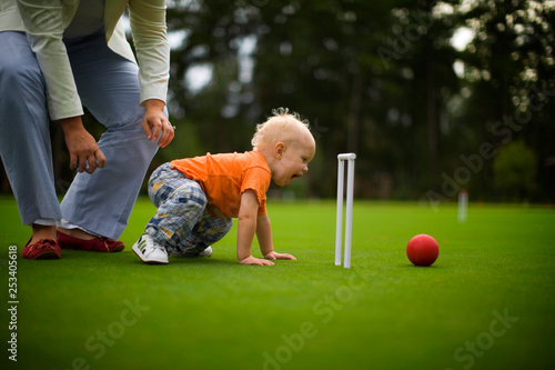 Toddler playing on a croquet course. photo