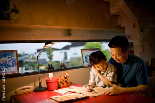 Mature man sitting reading with his son.