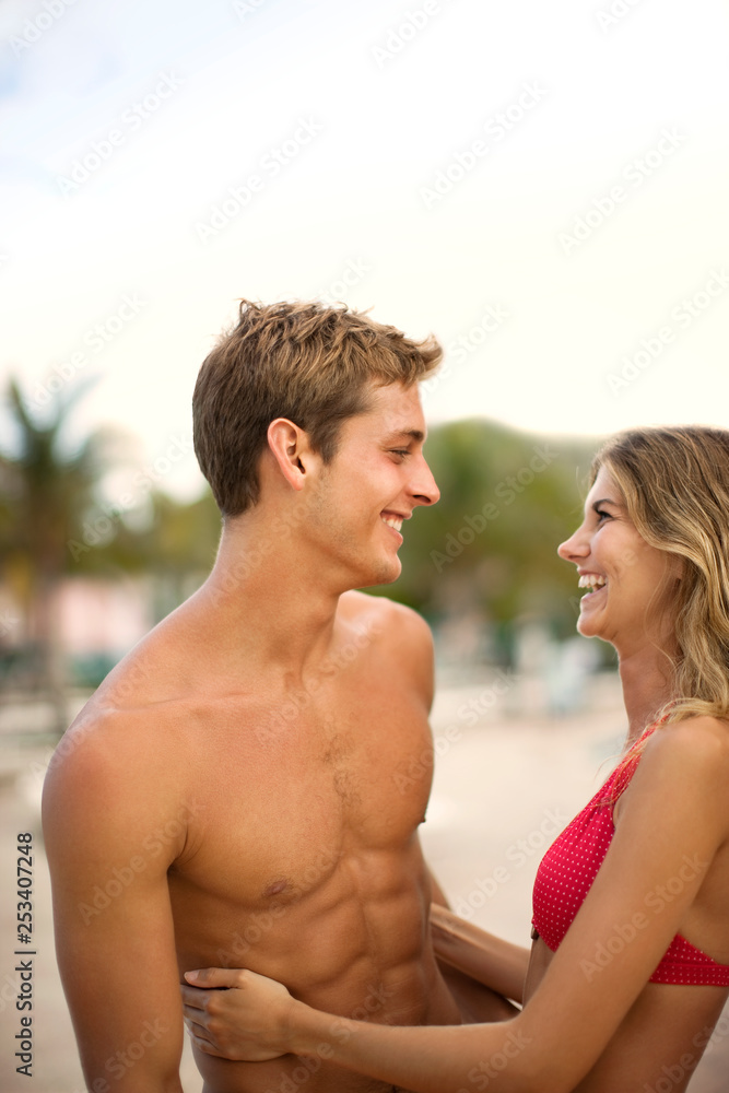 Laughing young couple looking at each other while hugging. Laughing young couple looking at each other while hugging.