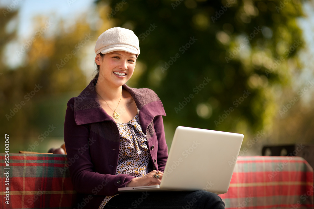 Portrait of a smiling teenage girl sitting with a laptop computer. Portrait of a smiling teenage girl sitting with a laptop computer.