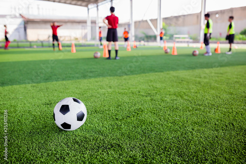 football on green artificial turf with blurry soccer players © Koonsiri