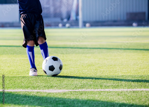 Fototapeta Naklejka Na Ścianę i Meble -  Kid soccer player speed run to shoot ball to goal on green grass.