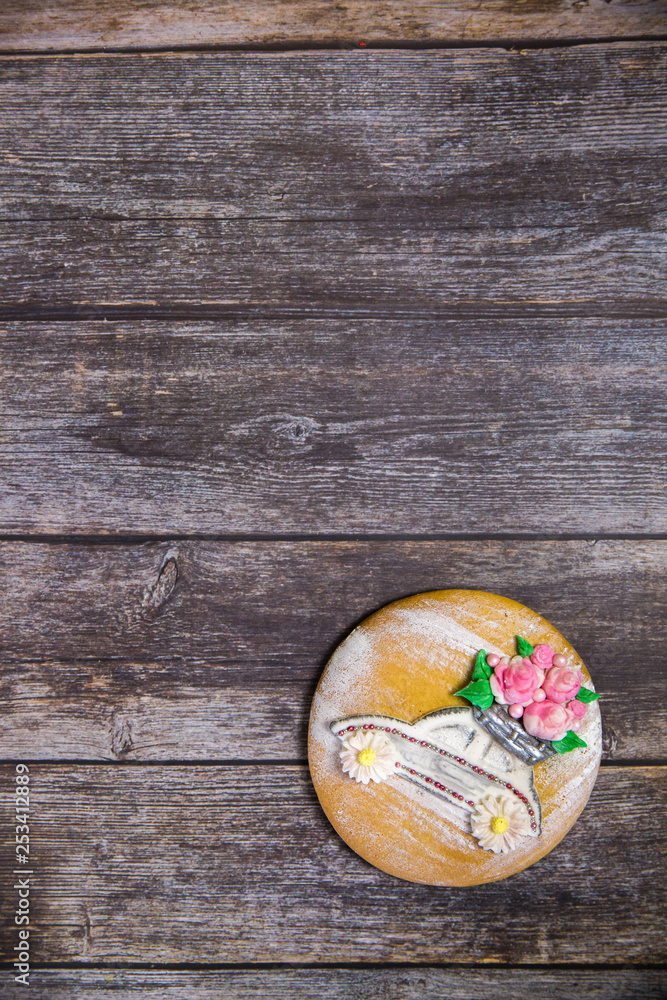 Round handpainted gingerbread on wooden background. Beautiful car with flowers. Flat lay. Copy space. Sweet dessert as a gift for women's day on 8 March