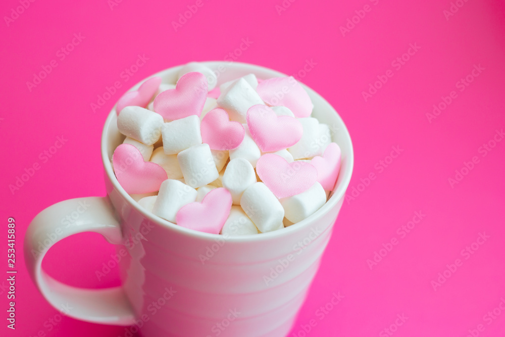 Mug with marshmallows in the shape of heart on pink background Mug with marshmallows in the shape of heart on pink background
