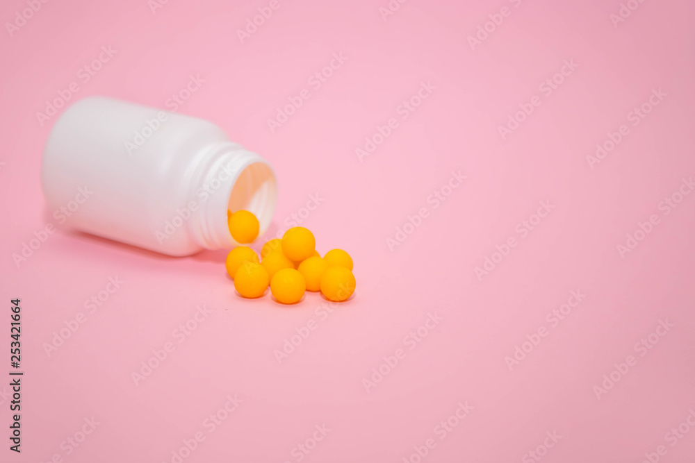 yellow vitamins in a white jar on a pink background. White bank with place for text and tablets. dietary supplements, tablets, vitamins, capsules. The concept of a healthy life. yellow vitamins in a white jar on a pink background. White bank with place for text and tablets. dietary supplements, tablets, vitamins, capsules. The concept of a healthy life.