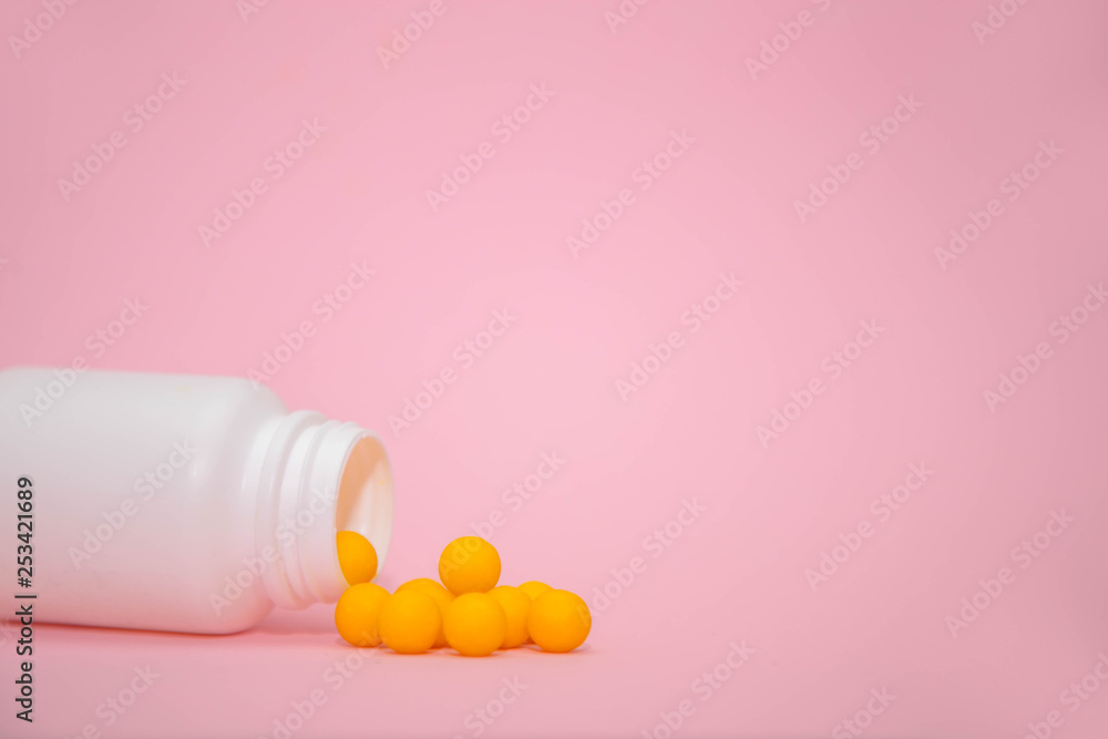 yellow vitamins in a white jar on a pink background. White bank with place for text and tablets. dietary supplements, tablets, vitamins, capsules. The concept of a healthy life. yellow vitamins in a white jar on a pink background. White bank with place for text and tablets. dietary supplements, tablets, vitamins, capsules. The concept of a healthy life.