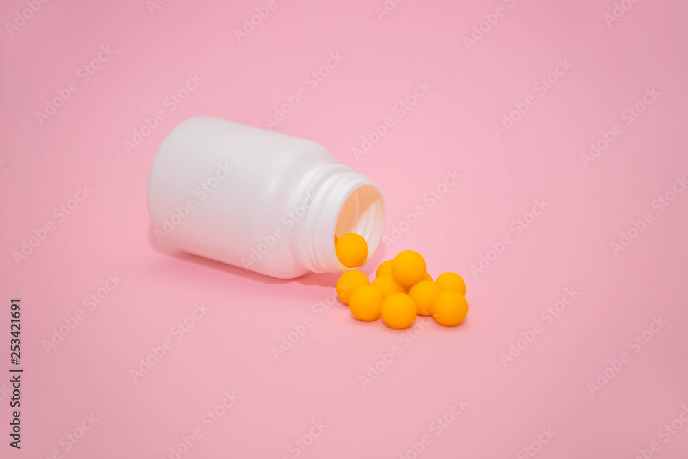 yellow vitamins in a white jar on a pink background. White bank with place for text and tablets. dietary supplements, tablets, vitamins, capsules. The concept of a healthy life. yellow vitamins in a white jar on a pink background. White bank with place for text and tablets. dietary supplements, tablets, vitamins, capsules. The concept of a healthy life.