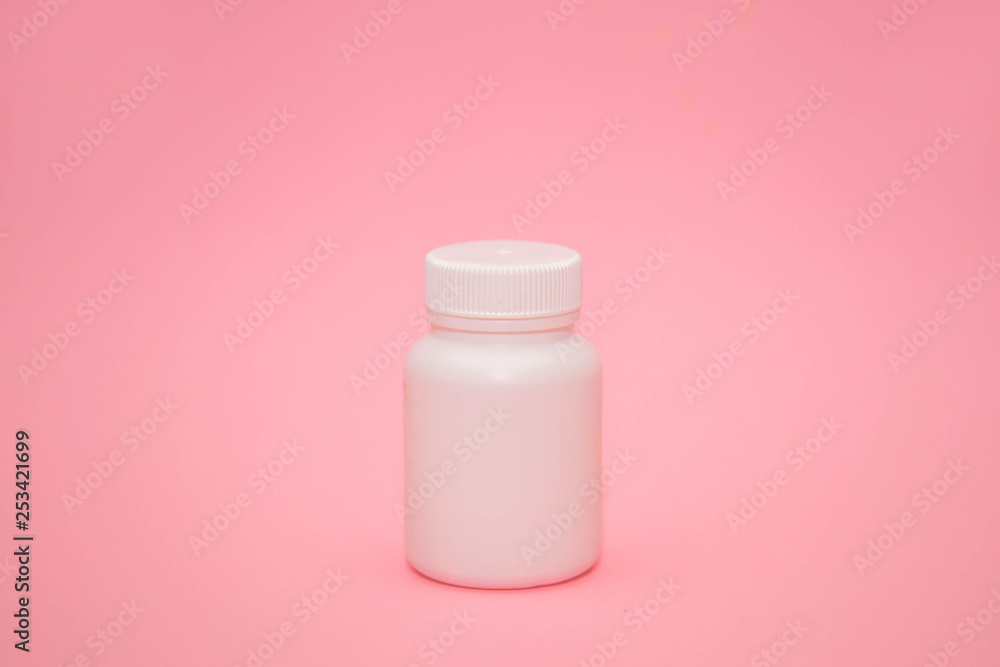 White jar with place for text and pills on pink background. dietary supplements, tablets, vitamins, capsules. The concept of a healthy life. White jar with place for text and pills on pink background. dietary supplements, tablets, vitamins, capsules. The concept of a healthy life.