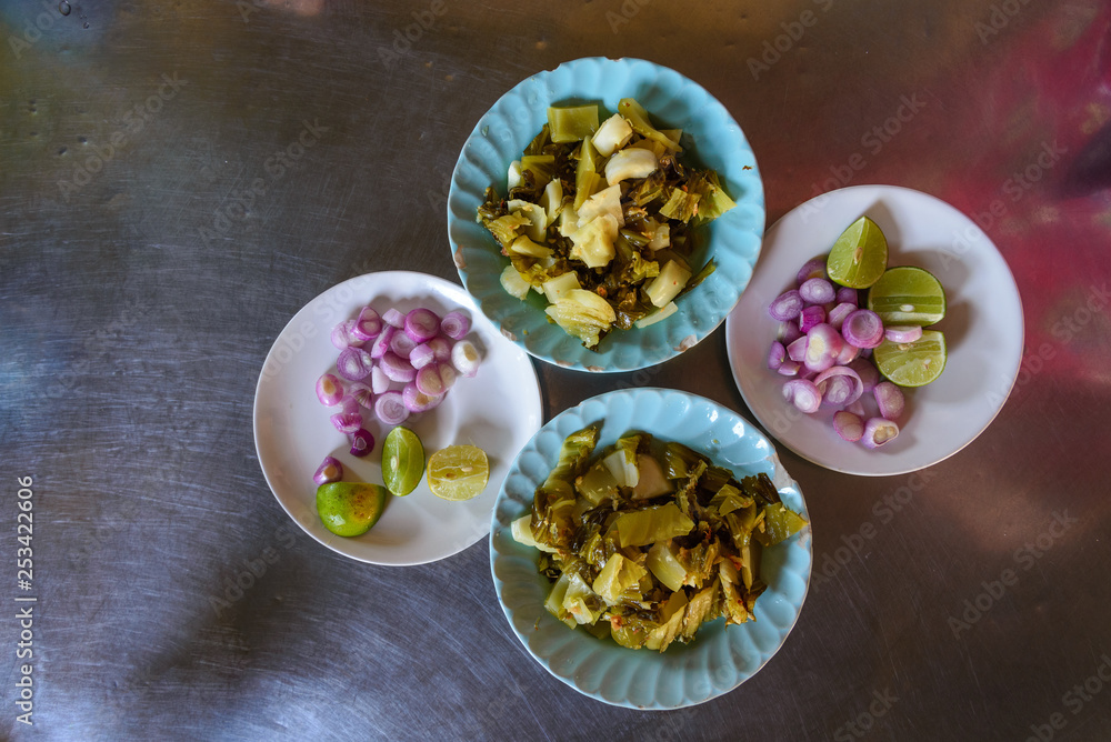 Top view set of vegetable side dish for Khao Soi or Khao Soy noodle consist of lime, red onion and cabbage pickle served on 4 dishes on stainless steel table. Top view set of vegetable side dish for Khao Soi or Khao Soy noodle consist of lime, red onion and cabbage pickle served on 4 dishes on stainless steel table.