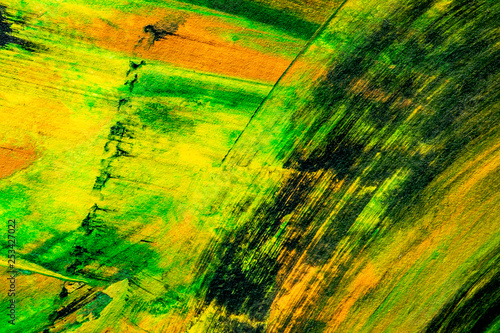 Paint texture abstract background. Colorful macro close up paint brush strokes green, yellow, orange, black. 