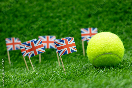 Obraz na plátne Tennis ball with Union Jack flag on green grass