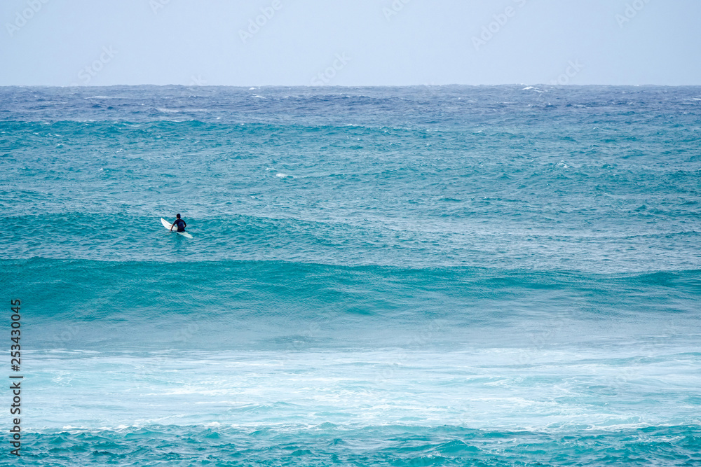 Surfer patiently waiting for the perfect wave