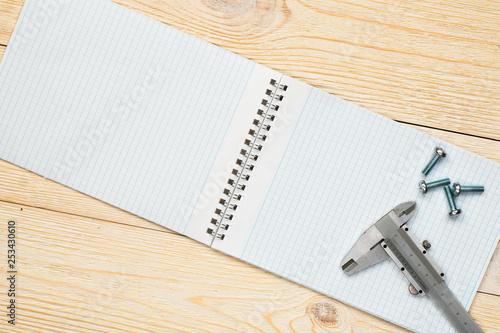 Canvas-taulu trammel and screw with empty notebook over wooden workbench