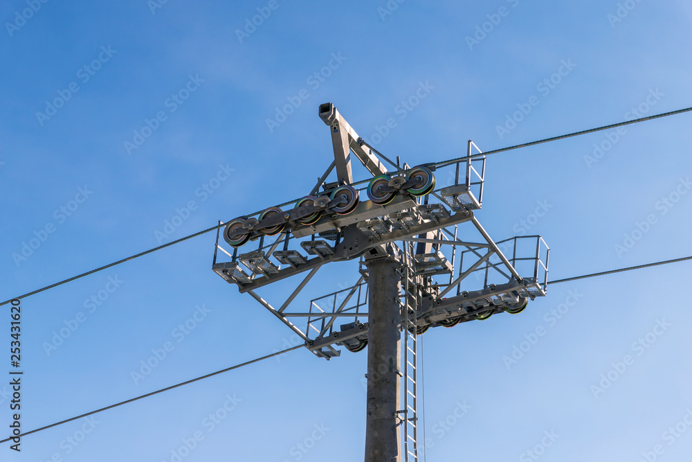 Steel ropes over wheels. Close up view of ski lift mechanism on top of support pillar. Steel ropes over wheels. Close up view of ski lift mechanism on top of support pillar.