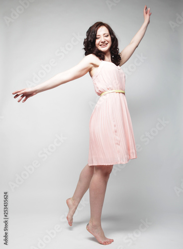young woman with curly hair wearing pink dress