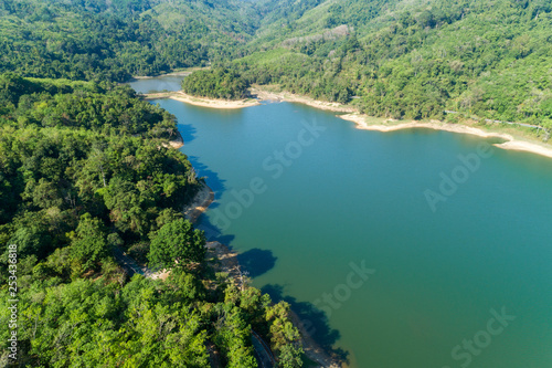 Top down from Drone aerial view of rainforest with asphalt road around the dam