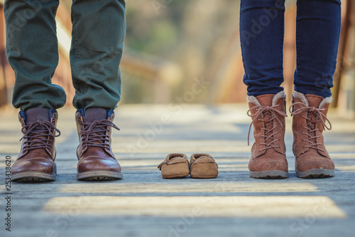 Couple standing with baby shoes in between them