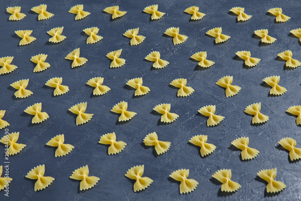 Italian raw pasta farfalle on a dark background. Bow tie, butterfly. Top view. Italian raw pasta farfalle on a dark background. Bow tie, butterfly. Top view.