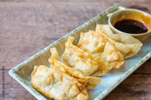 Fried Jiaozi with dipping sauces on wood table background photo