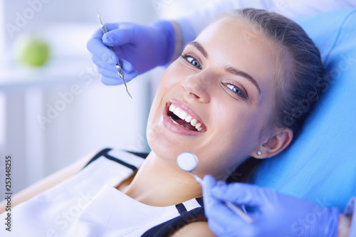 Photo Young Female patient with open mouth examining dental inspection at dentist office