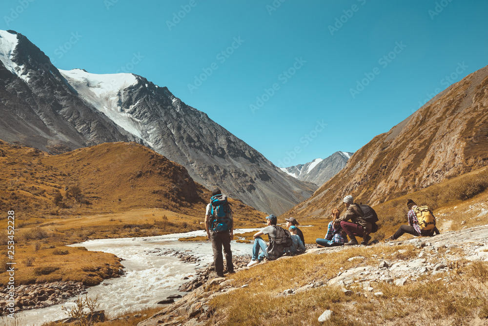 Big group hikers against mountains and river
