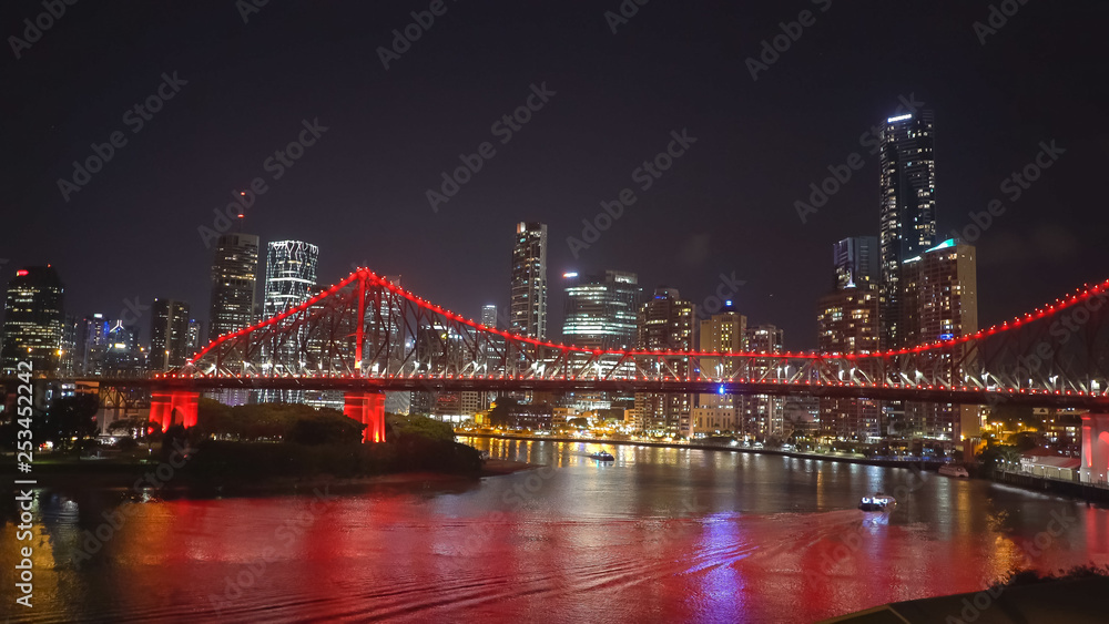night time shot of the story bridge and ferry in brisbane
