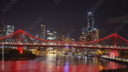 night shot of the story bridge in brisbane illuminated with red lights © chris