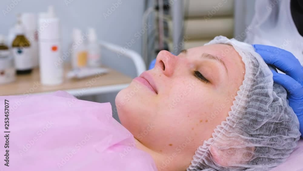 Beautician washes woman's face using cotton pads from mask. Cleaning face. Beautician washes woman's face using cotton pads from mask. Cleaning face.