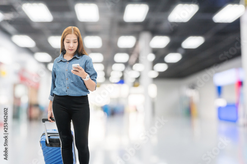 Asian Traveler women looking for flight in smartphone at airport terminal Travel concept