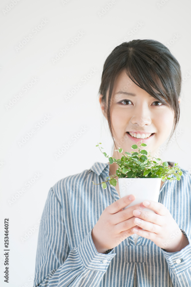 植物を持ち微笑む女性 植物を持ち微笑む女性