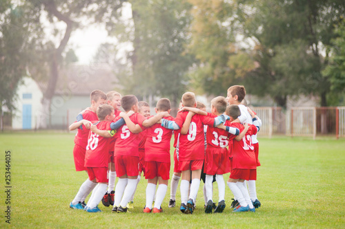 Young soccer players in hug celebrating victory