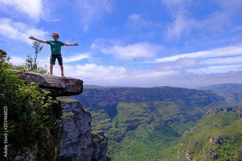 The cliffs of the Cachoeira Da Fumaca, Smoke Waterfall, with a hiker standing on the edge, Vale Do Capao, Bahia, Brazil photo