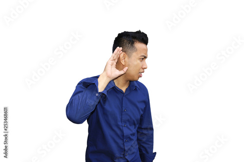 Photo image portrait of young Asian man holds his hand near his ear and listening over white background