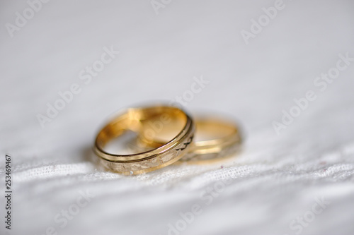 dos anillos de boda de oro sobre superficie blanca