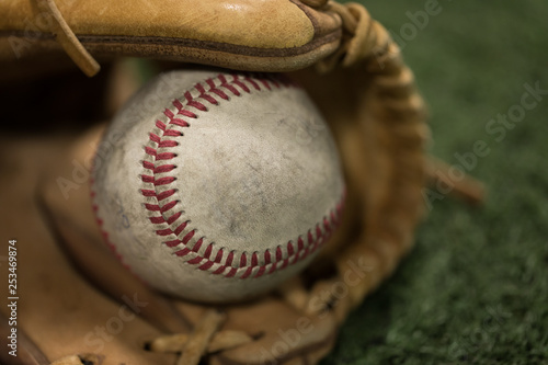 Photography Closeup of baseball in glove on turf