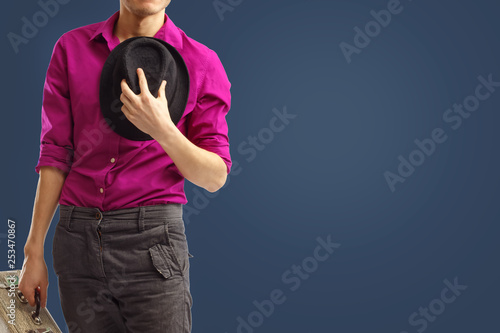 Obraz na plátne Young trendy dressed gentleman took off his hat and pressed it to his chest in greeting, declaring his openness to communication